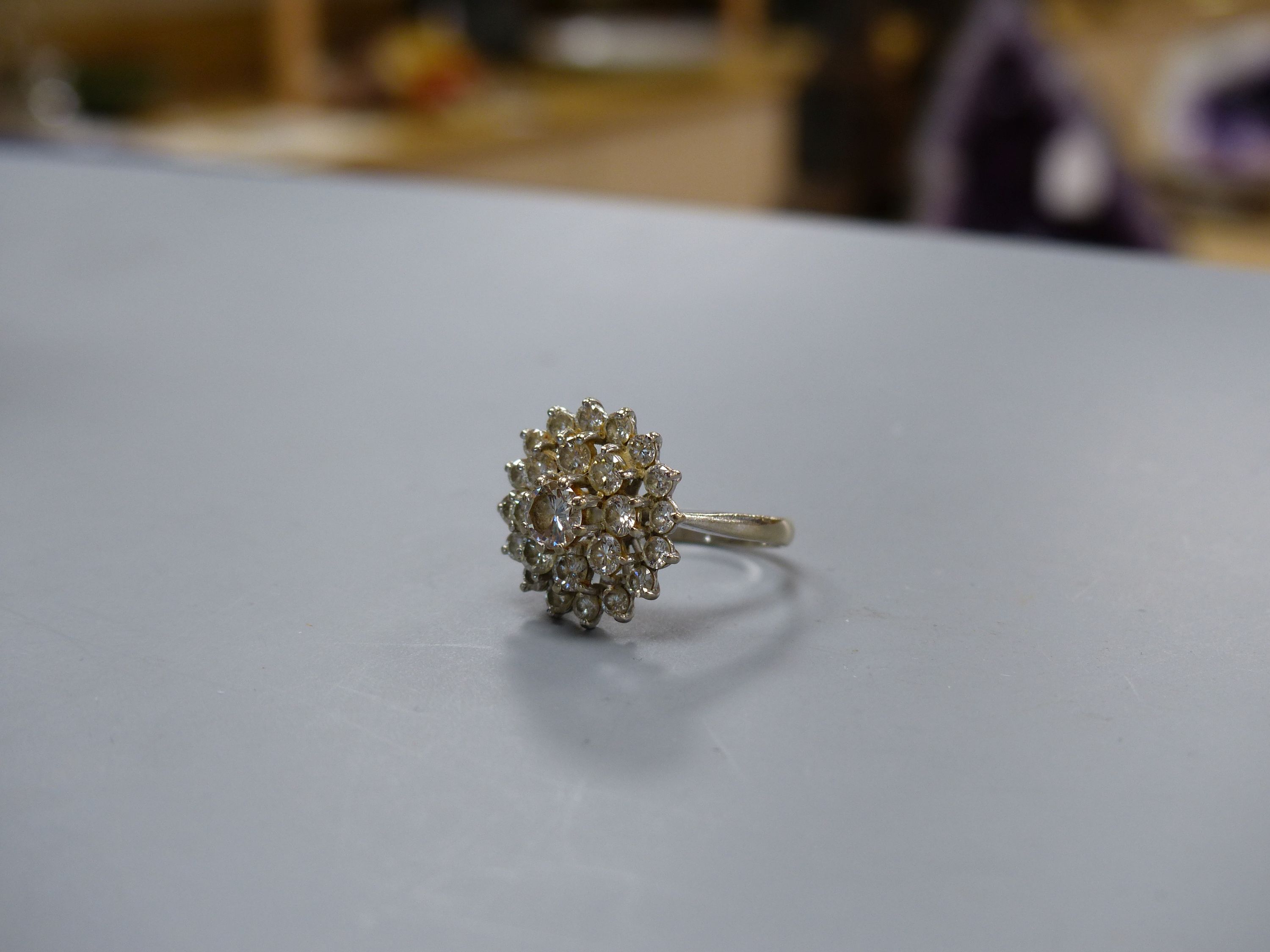 A twenty-five stone graduated cluster diamond ring, claw-set in platinum, size M, gross weight 5.7 grams.